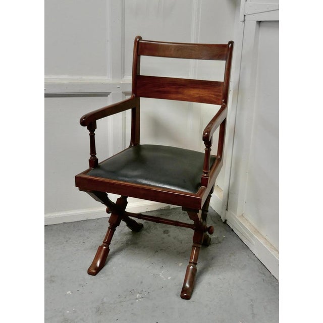 Arts & Crafts X-frame mahogany desk chair. The chair is set on X-framed Legs, a very strong design, it has elegant arm...