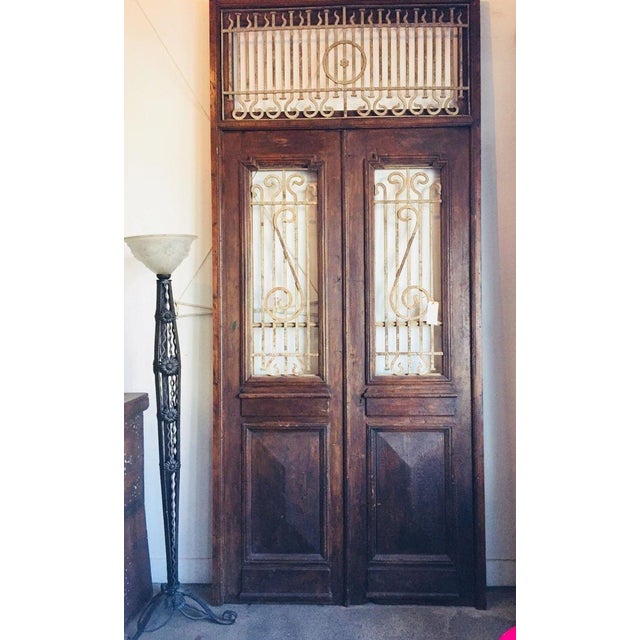 Antique French Painted Double Entry Doors with Transom — Carved Wood and Wrought Iron A grand and character-rich set of...