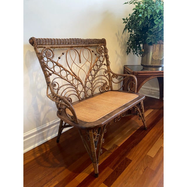 A truly charming and intricate example of turn-of-the-century American wicker craftsmanship, this vintage rattan settee...