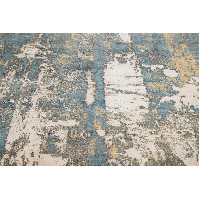 Beautiful modern Tibetan Indian wool & silk rug with a beige field in an abstract patterning blue, gray, and tan color....