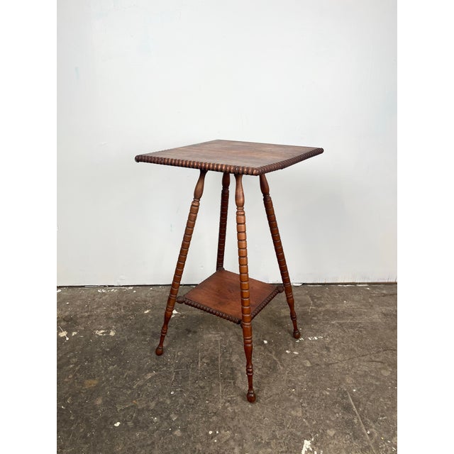 Antique Victorian spool bobbin side table. Square top and small lower shelf bobbin ball trim. Spool style turned legs.