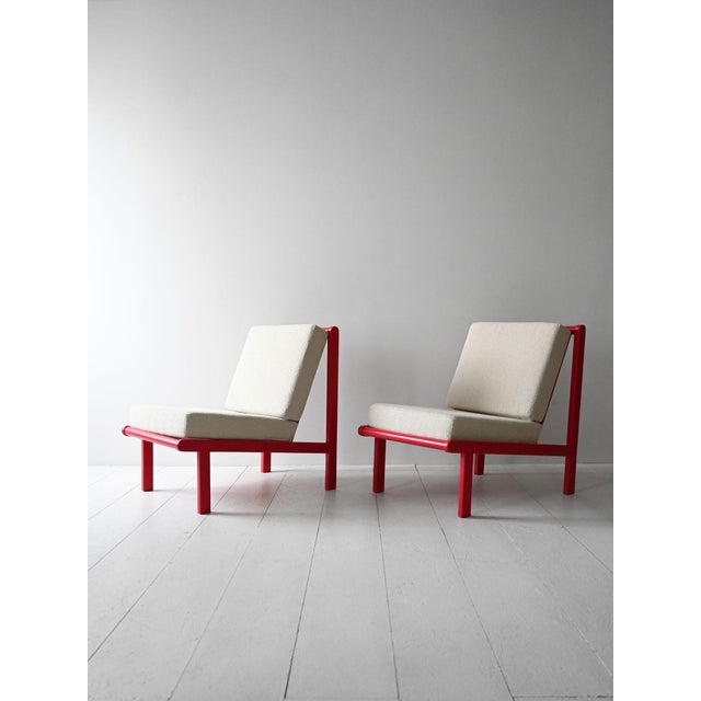 Pair of 1970s armchairs with cherry red lacquered structure and redone and reupholstered cushions. Essential and graphic...