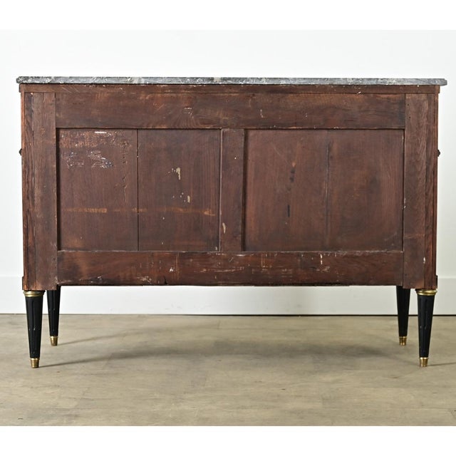 Dimensions: 32 ¾” H x 47 ¾” W x 21” D A Louis XVI style, marble-topped commode from France (late 19th century) in a bold,...