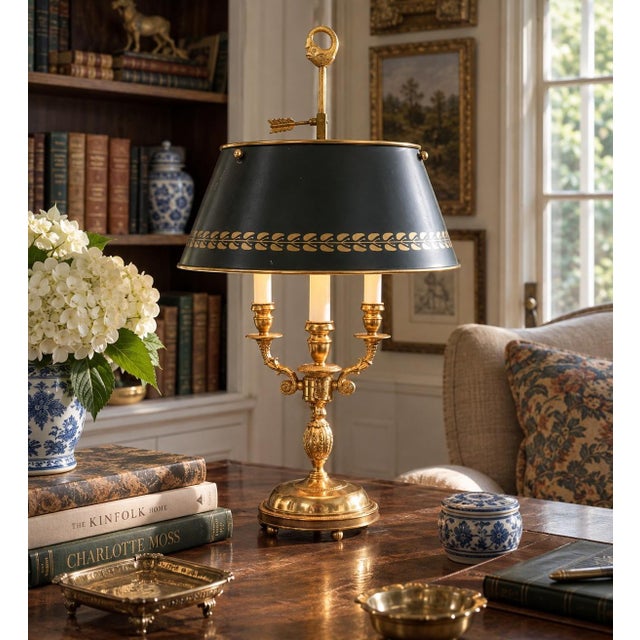 A classic bouillotte lamp rendered in warm brass, distinguished by its sculptural acanthus leaf motif and clean, tailored...
