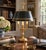 A classic bouillotte lamp rendered in warm brass, distinguished by its sculptural acanthus leaf motif and clean, tailored...