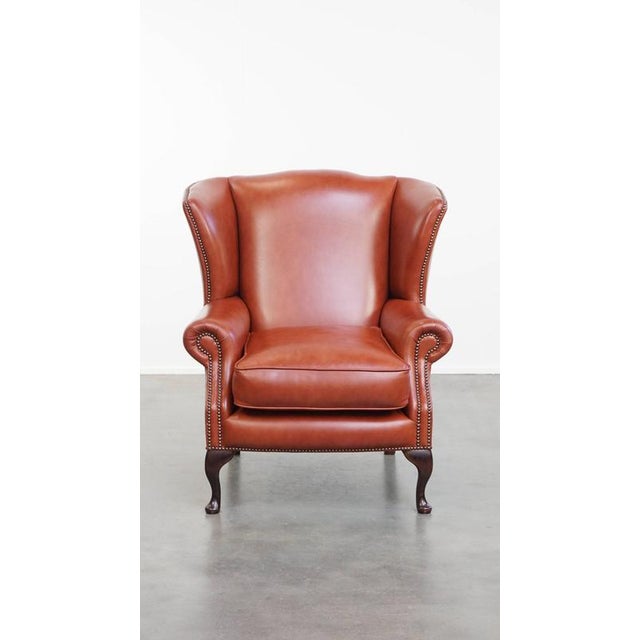Offered this elegant, smooth and comfortable English chesterfield ear chair made of cowhide leather, with decorative legs....