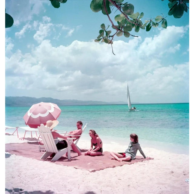 Jamaica Parasol by Toni Frissell An intimate group of people enjoying a conversation in the sunshine on a pastel pink...