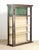 Vintage brass free standing display case with glass sides and doors. The upper cabinet has a green interior, while the...