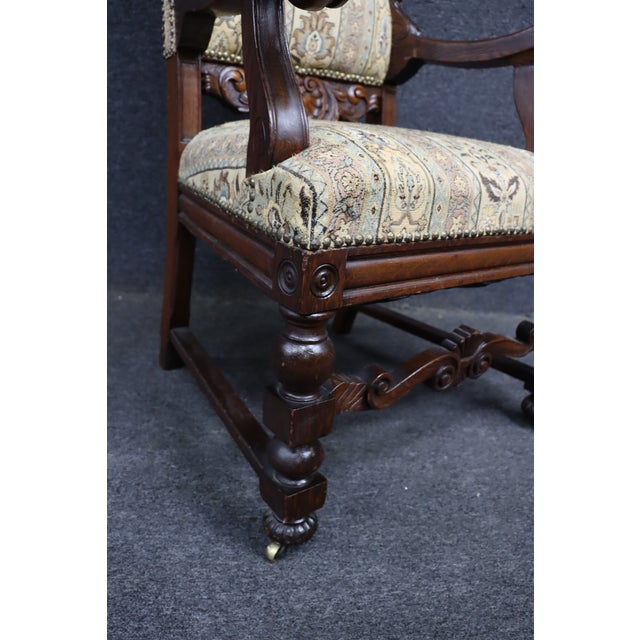 An antique Renaissance Revival throne armchair crafted in quarter sawn oak, featuring a carved crest with scrolling...