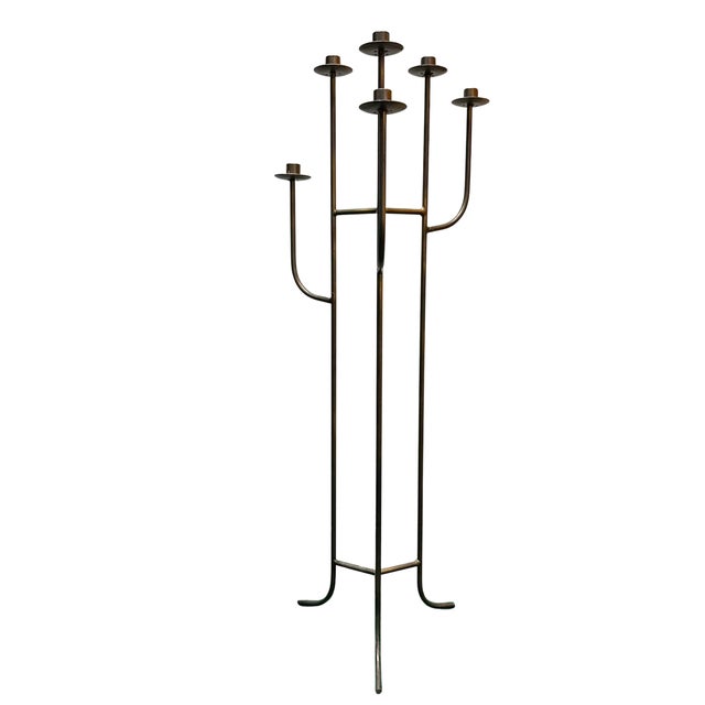 This striking vintage floor candelabra features a sculptural six-arm design crafted from wrought iron with a warm bronze-...
