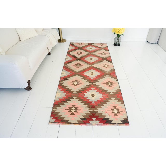 This is a vintage Turkish Oushak rug from the Mid 20th Century. The piece was hand-knotted.