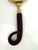 A vintage handheld magnifying glass featuring a substantial brass frame and sculptural handle with a ribbed wood-tone...