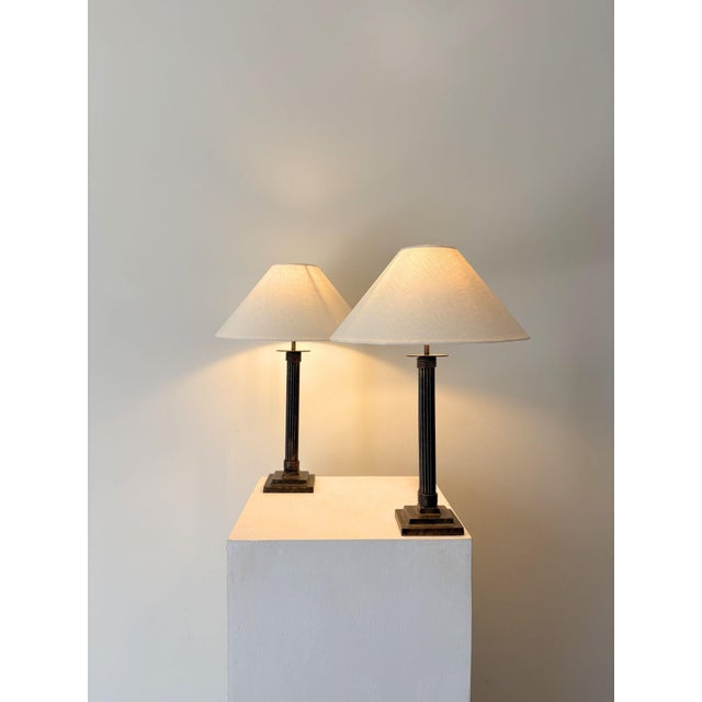 A pair of 20th century cast metal column lamps. These simple table lamps have subtle neoclassical and art deco design...
