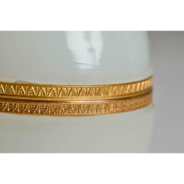 Stunning large antique French white opaline glass egg-shaped box. The box has gilt decor on the top and gilt banding...