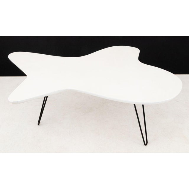 Jens Risom Modernica "Amoeba" Style Coffee Table, white laminate table top above patinated steel tripod base. 17.25" H x...