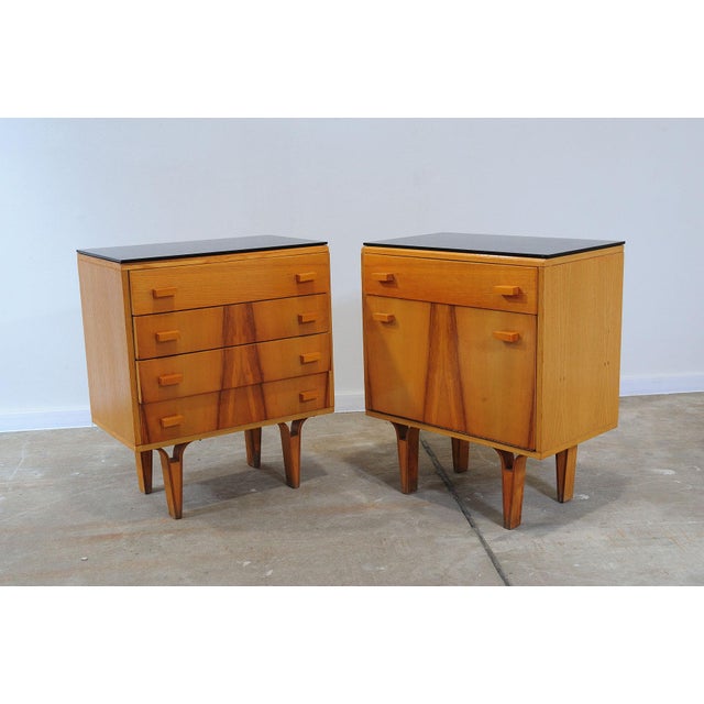 A clean-lined pair of nightstands with striking vertical wood grain and contrasting black glass tops. This set of two...