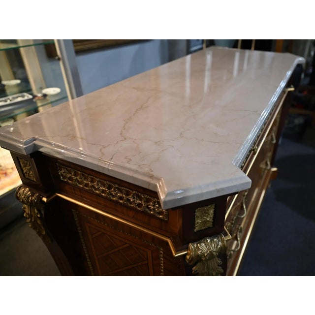 A very fine quality Louis XVI Style ormolu-mounted commode or chest of drawers with an Italian white marble top that is...