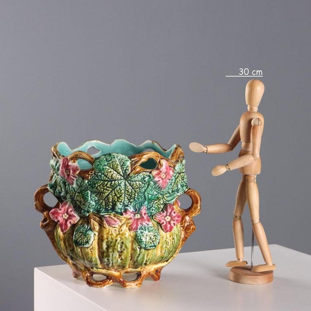 Polychrome ceramic vase. Base, handles, and mouth decorated with vines. Relief decoration depicting leaves and flowers....