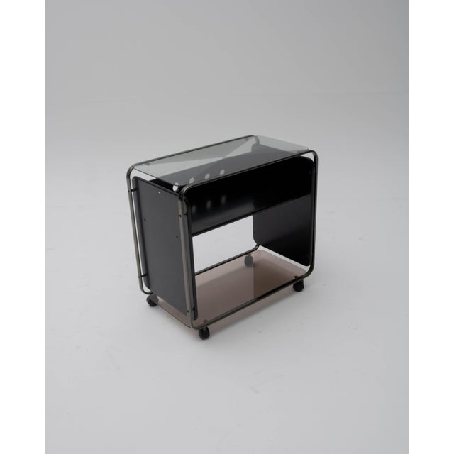 A vintage TV stand or utility cart, designed in the aesthetic style of Italian functionalism and Central European...