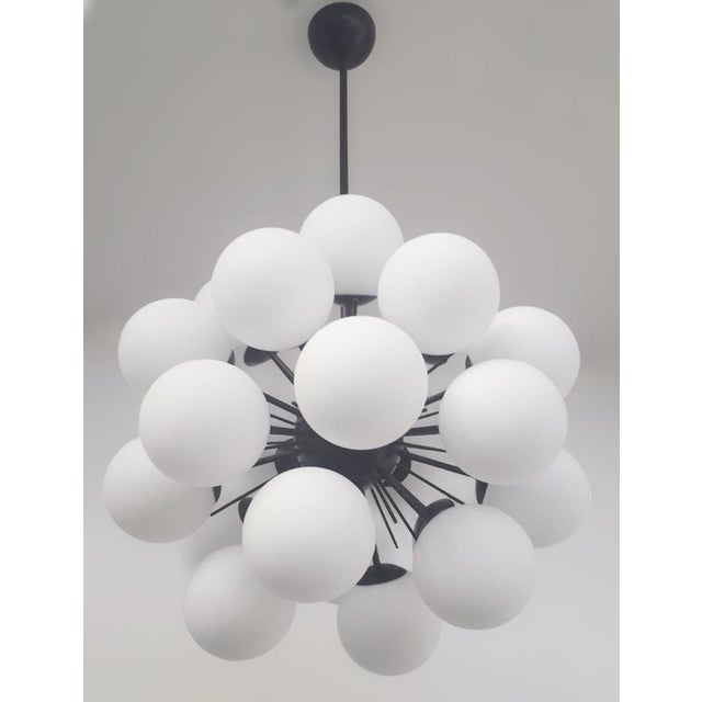 Italian sputnik chandelier with 24 matte white Murano glass globes mounted on black powder coat finish frame / Made in...
