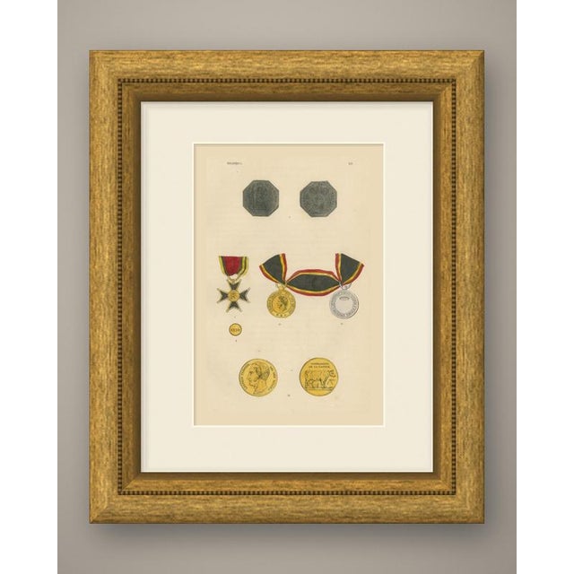 This is an original antique wood engraving, colored by hand, showing belgian medals and a decoration. At the top are both...