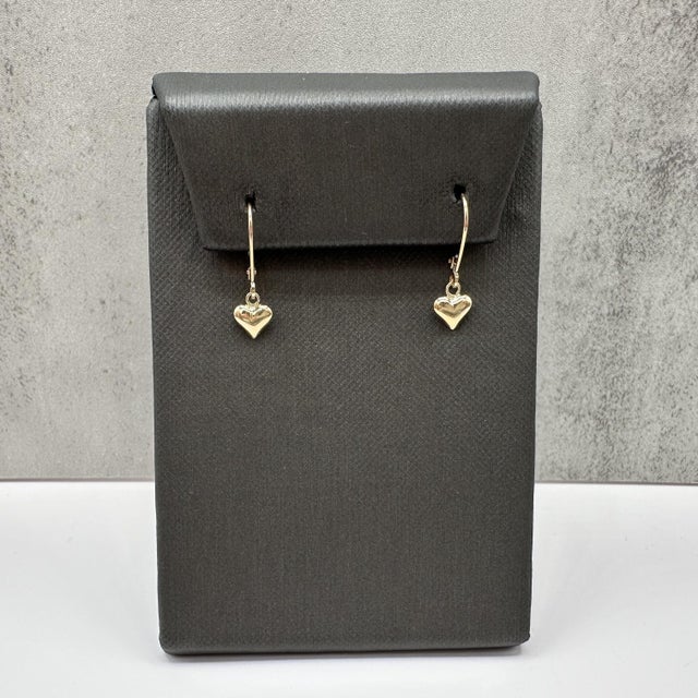 These heart dangle earrings are crafted in 10kt yellow gold and feature a charming heart motif suspended from secure lever...