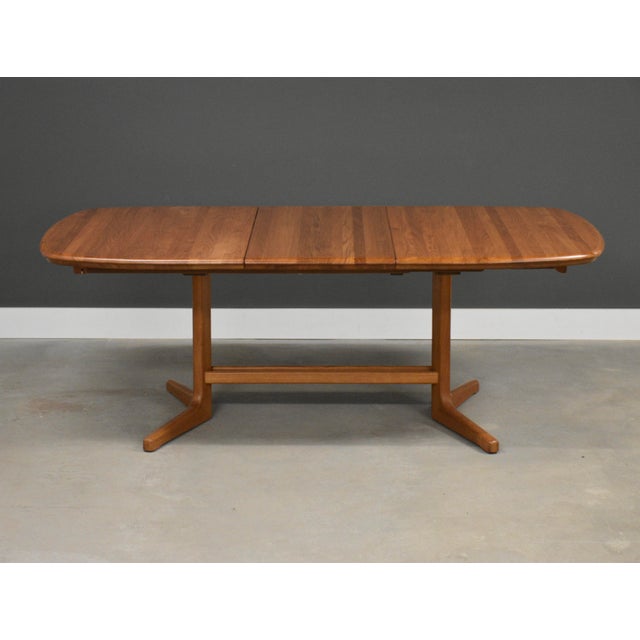 A mid century modern solid teak dining table with two 20” leaves and a pedestal base. We believe it was made in Denmark....