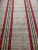 Antique hand woven rag textile with two bright stripes along the length of the piece in red, green, yellow against a light...