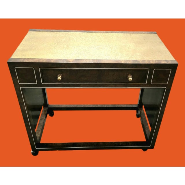 Featured is a vintage Hollywood Regency Mastercraft Drop-Leaf Amboyna Burl and Textured Brass Bar Cart. Enhanced by a...