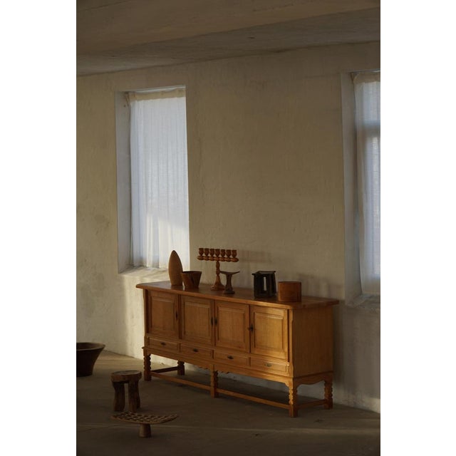 Charming low-profile modern sideboard crafted from oak, featuring an elegantly carved front and generous storage capacity....