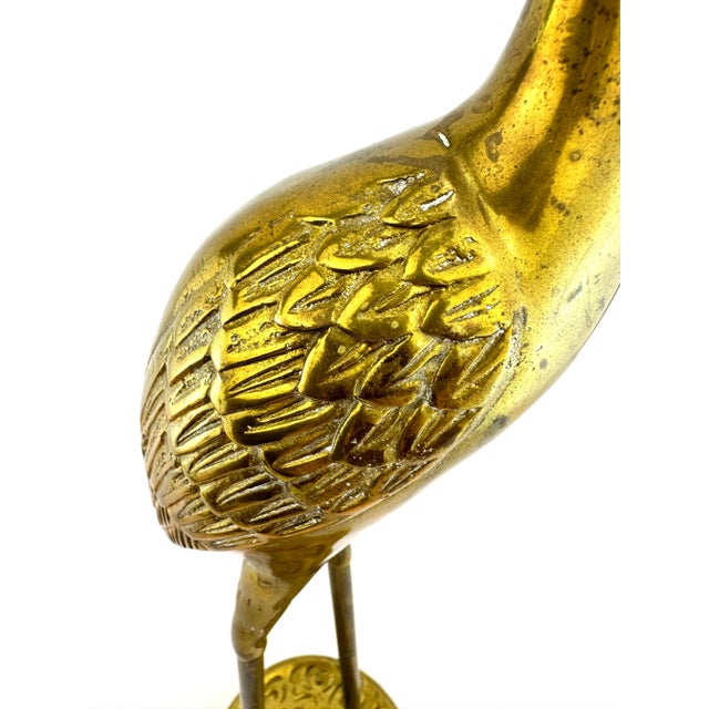 Elegant set of three tall vintage brass crane sculptures, each showcasing elongated necks, slender legs, and finely etched...