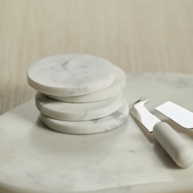 A solid slab of white marble with its smooth, substantial design features an ample, free form accentuated by natural,...