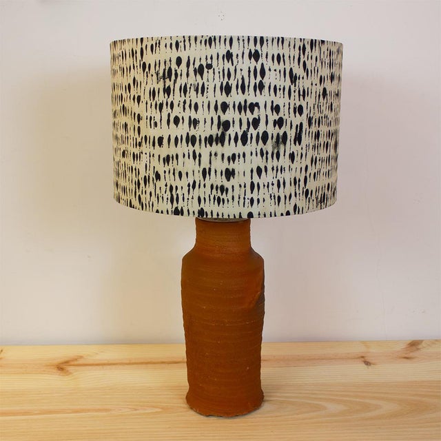 Table lamp with a base made from an antique terracotta earthenware pipe and a cylindrical fabric shade with a ecru and...