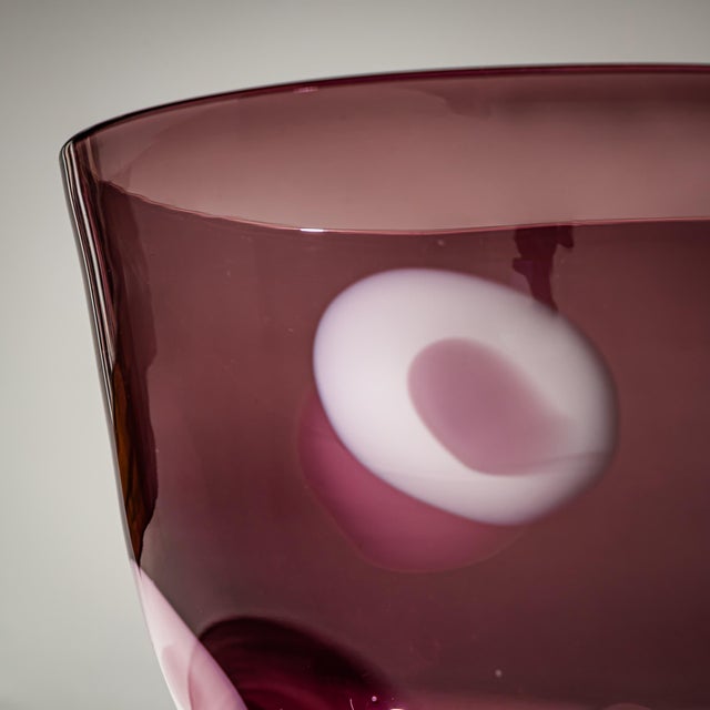 Large glass vase with a smooth, conical body in translucent wine-red glass with oval white inclusions. Label of the Dutch...