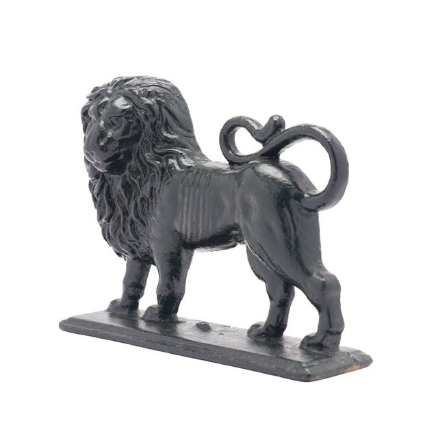 Painted English Victorian cast iron lion doorstop with hollow back. The lion features a full mane and curled tail and...