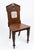 This antique hall chair features a distinctive pediment-style back and a triangular seat, characteristic of late Victorian...