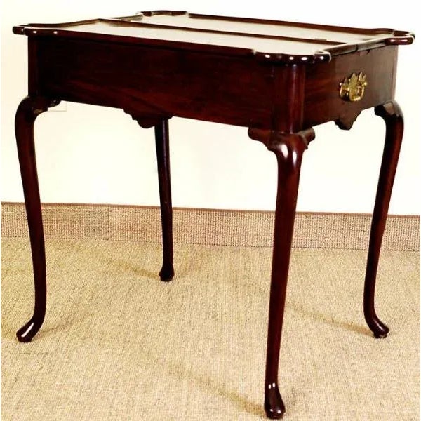 A very unusual English c.1760, Queen Anne mahogany bifurcated porringer top tea table. A shaped and divided top with...