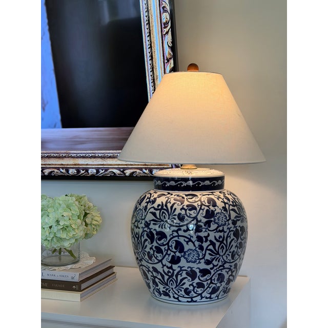 A striking extra-large blue and white porcelain lamp base with an ornate, all-over floral and scrolling vine design. The...