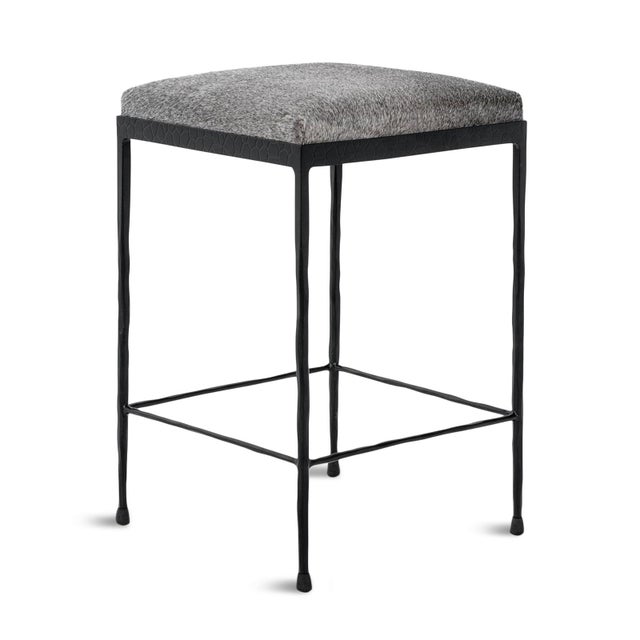 Modern lodge style counter stool with grey hide square seat. Hand hammered dark bronze finish iron legs. Each stool unique...