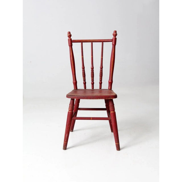 This antique children's chair is a charming example of vintage craftsmanship and playful design. The petite red-painted...