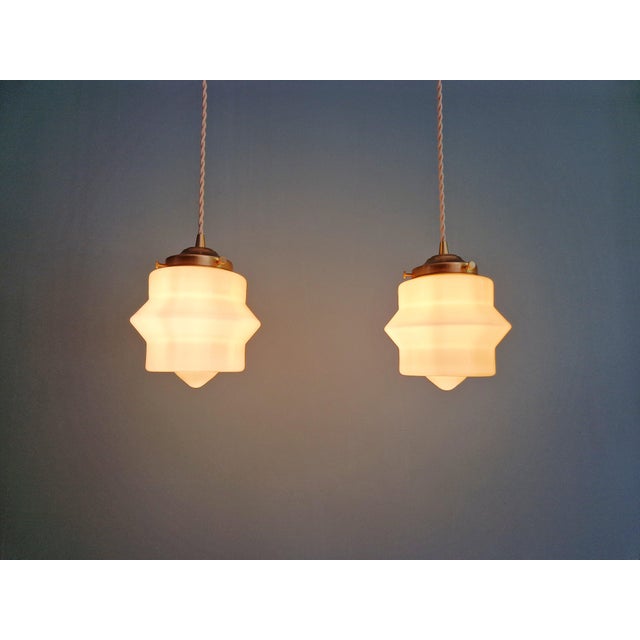 Pair of Art Deco cream-colored opaline glass pendant lights, 1930s. Each pendant light has been restored and is compatible...