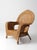 A vintage wicker armchair with a high, shaped back and gently curved arms, finished in a warm honey tone that lends an...
