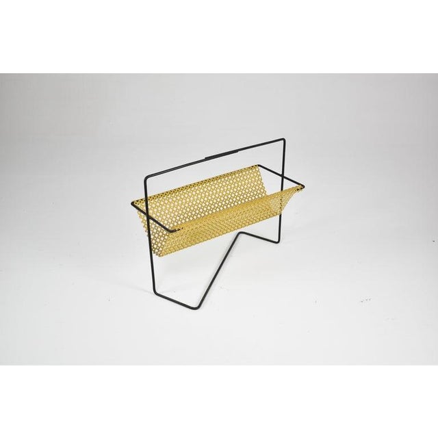 French magazine rack, 1950s–60s constructed from black lacquered tubular steel with a folded perforated metal body in...