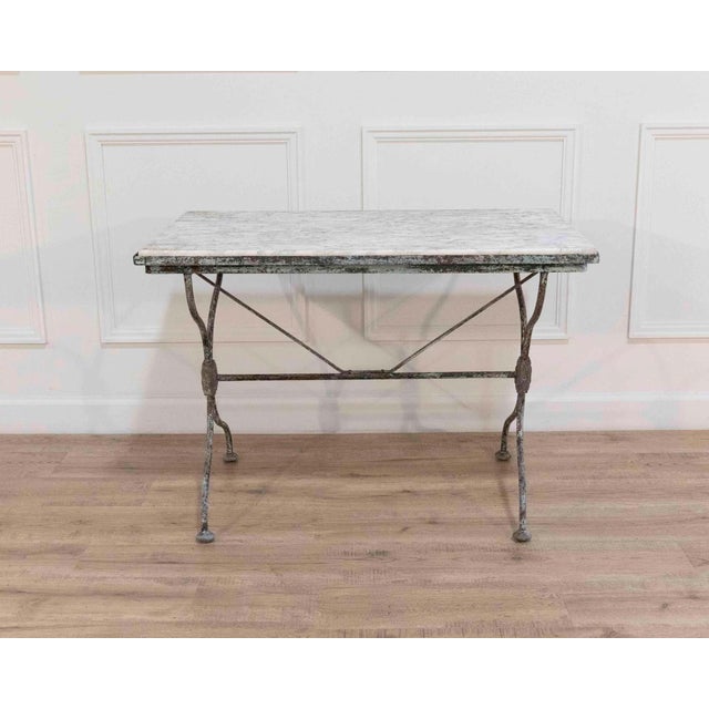 A distinctive nineteenth-century French wrought iron table, showcasing exceptional craftsmanship and a richly aged...
