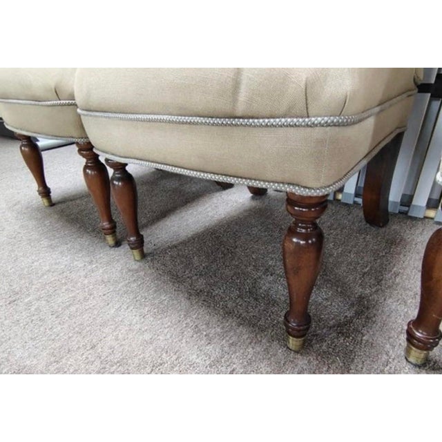 This set of four custom upholstered dining chairs features classic scroll back silhouettes, tailored nailhead trim, and...