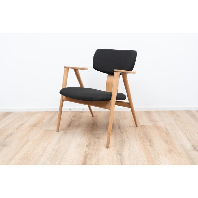 FB14 Armchair by Cees Braakman. The chairs comes with a black upholstery on the seating and backpiece on a wooden frame. I...