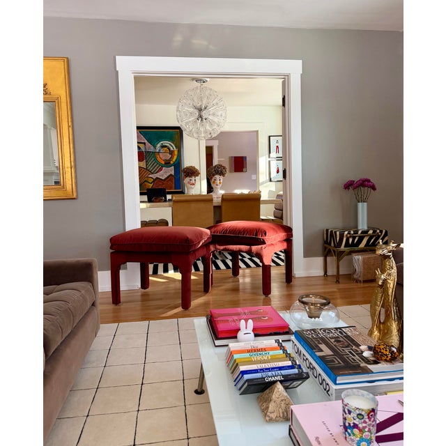 We are very pleased to offer this striking pair of red velvet ottomans, circa 1970s, defined by sculptural lines and...