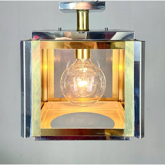 A striking mid century modern semi-flush cube light fixture by Robert Sonneman featuring chrome and brass finishes and...