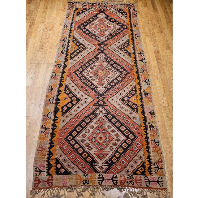 A striking example of Anatolian village weaving, this early 20th-century Vintage Turkish Kilim Wide Runner embodies the...