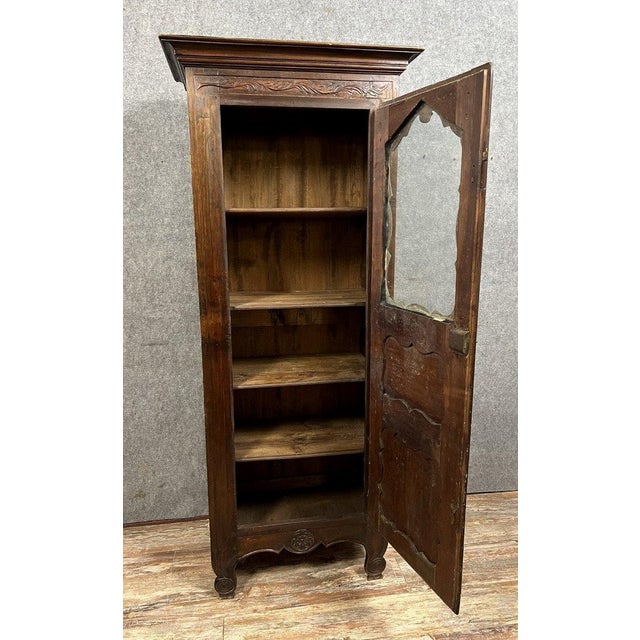 Louis xv period provençal bonnetière in solid oak opening with a paneled door, glazed at the top carved decorations curved...